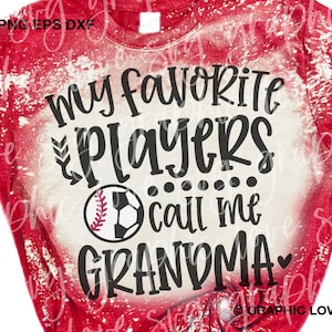 May include: Red and white distressed t-shirt with the text "My favourite players call me grandma" in black with a baseball and football graphic.