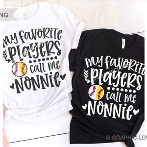 May include: Two black and white t-shirts with a softball graphic and the text "My favorite players call me Nonnie".