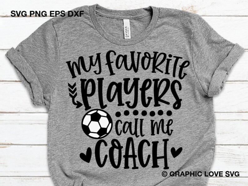May include: Gray t-shirt with black text that reads "My favorite players call me coach" with a black and white soccer ball graphic and two black hearts.