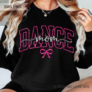 May include: Black sweatshirt featuring the text "DANCE MOM" in a pink glitter design. A pink bow is below the text. The sweatshirt is a crew neck style.