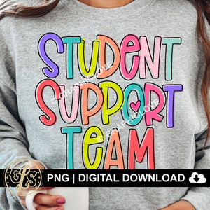 May include: A gray sweatshirt with the text "STUDENT SUPPORT TEAM" in colorful, outlined letters. The letters are in different colors, including pink, purple, yellow, green, and blue. A small red heart is included in the word "SUPPORT".