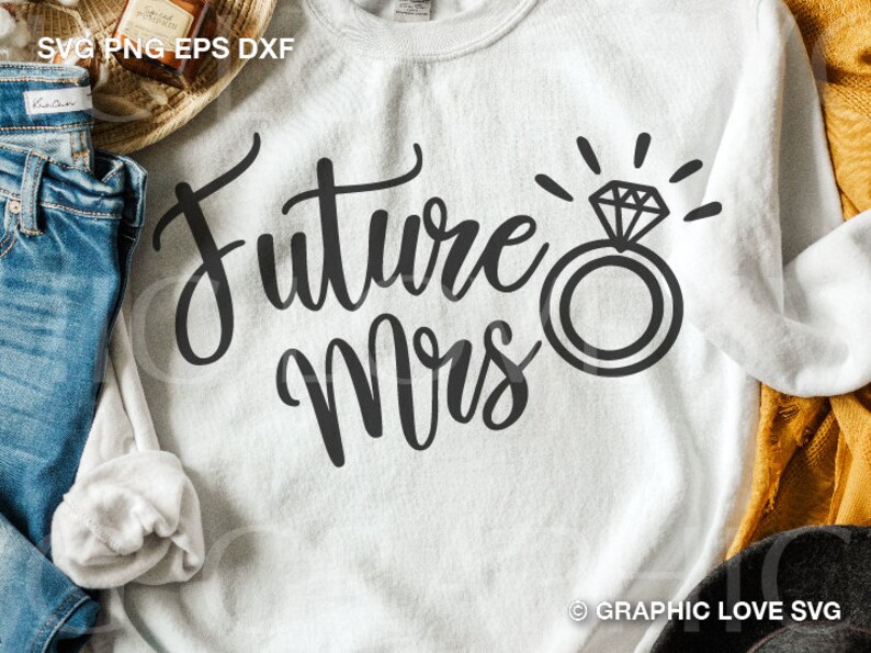 May include: White sweatshirt with the text "Future Mrs." in black cursive lettering and a black ring with a diamond graphic.