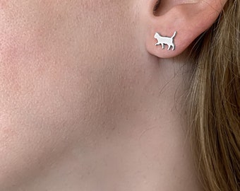 May include: A pair of silver cat silhouette stud earrings. The earrings are small and delicate, and they would make a great gift for any cat lover.