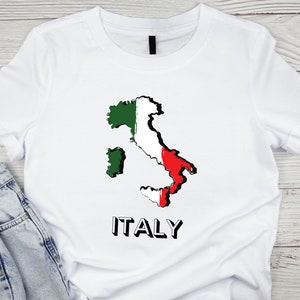 Peut inclure: T-shirt blanc avec un contour de l'Italie en vert, blanc et rouge, et le mot "ITALIE" imprim&eacute; en noir.
