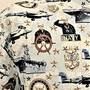 May include: A white and blue patterned shirt with a navy theme. The shirt features images of airplanes, ships, stars, and the words "USN" and "Navy".