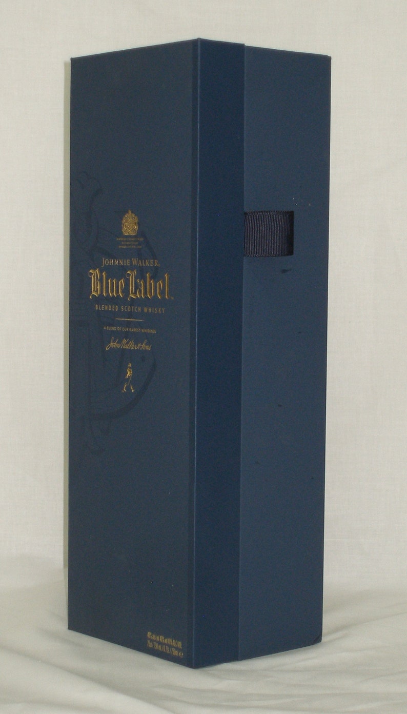 May include: A blue box with gold lettering for Johnnie Walker Blue Label Blended Scotch Whisky. The box has a gold crest and the words "Johnnie Walker" and "Blue Label" are printed in gold.