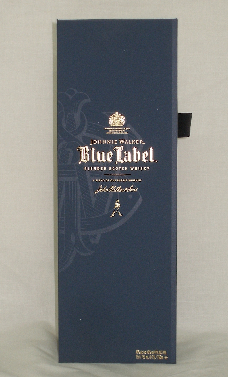 May include: A dark blue box with gold lettering for Johnnie Walker Blue Label Blended Scotch Whisky. The box features a gold anchor and the text "A blend of our rarest whiskies" and "John Walker & Sons".