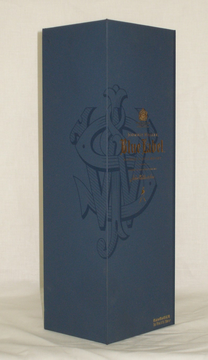 May include: A blue box with a gold logo and the text "Johnnie Walker Blue Label" printed on it. The logo is a stylized anchor with a crown above it.