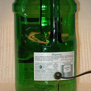 May include: A green glass bottle with a label that reads "Tanqueray" and "Distilled London Dry Gin". The bottle is a decorative lamp with a cord and plug.