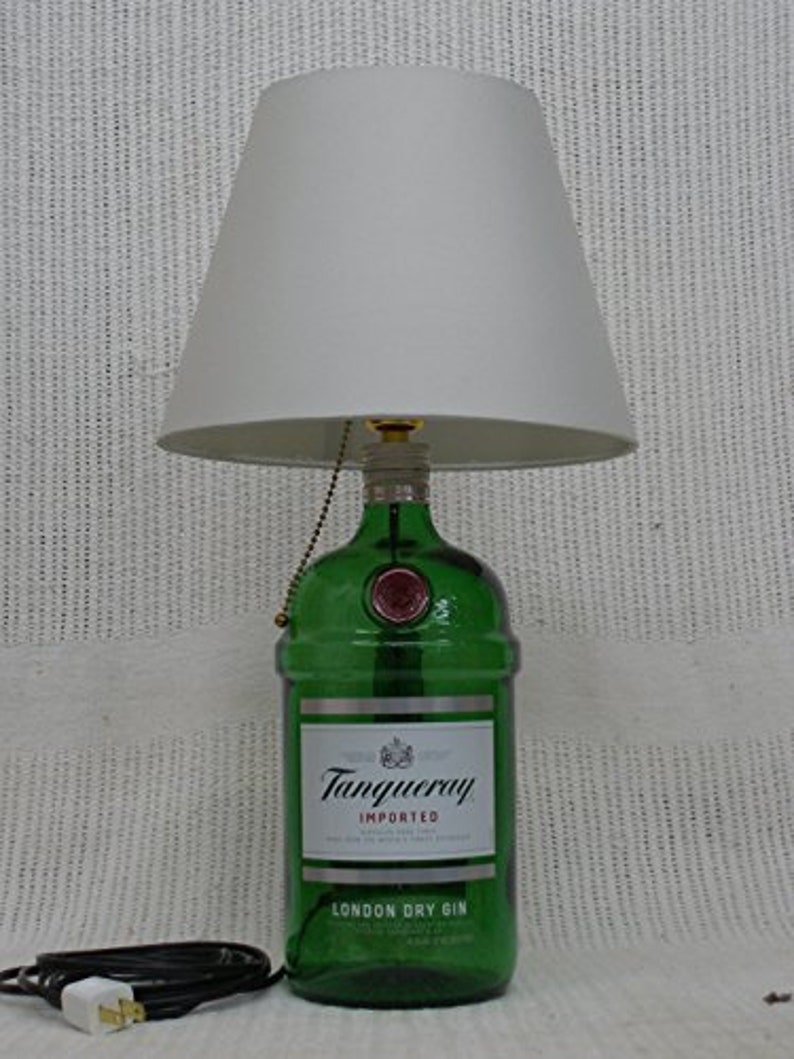 May include: A green glass bottle lamp with a white lampshade. The bottle is labeled "Tanqueray Imported London Dry Gin".