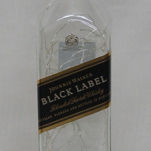 Peut inclure: Une bouteille en verre transparent de whisky &eacute;cossais Johnnie Walker Black Label, vieilli 12 ans. La bouteille porte une &eacute;tiquette noire avec des lettres dor&eacute;es et un sceau dor&eacute;.