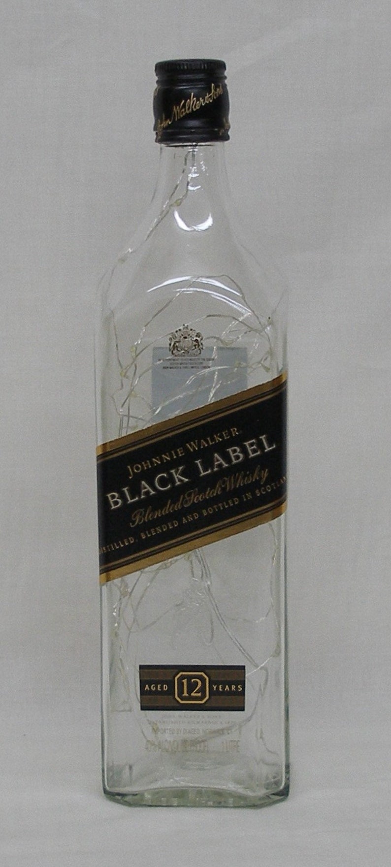 Peut inclure: Une bouteille en verre transparent de whisky &eacute;cossais Johnnie Walker Black Label, vieilli 12 ans. La bouteille porte une &eacute;tiquette noire avec des lettres dor&eacute;es et un sceau dor&eacute;.