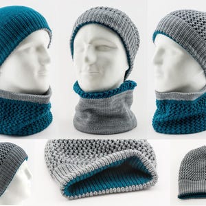 Op de afbeelding: Een set van twee omkeerbare gebreide mutsen en sjaals. De ene kant is grijs met een textuurpatroon, de andere kant is tealblauw. De mutsen en sjaals worden getoond op mannequins.