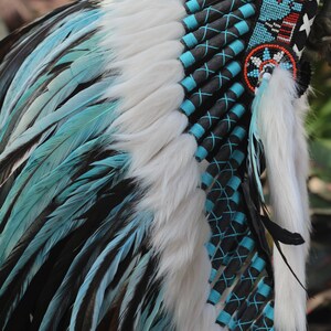 K&ouml;nnte beinhalten: Ein blauer und wei&szlig;er Indianer Kopfschmuck mit schwarzem und t&uuml;rkisfarbenem Besatz. Der Kopfschmuck besteht aus Federn und Fell.