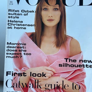 May include: Vogue magazine cover with a woman with auburn hair and blue eyes, wearing a pink top. The cover includes the Vogue logo and text: "Rifat Ozbek: sultan of style", "Helena Christensen at home", and "Catwalk guide to a great season."