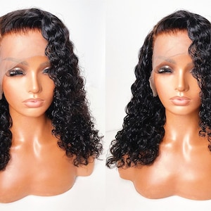 May include: A black curly human hair wig with a lace front. The wig is styled in a side part and has a natural-looking hairline.