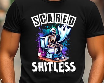 May include: Black t-shirt with a colorful graphic of a skeleton on a toilet, a ghost, and the words "SCARED SHITLESS". The design features a vibrant splash of colors and is a humorous take on Halloween.