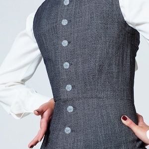 May include: A gray dress with a row of decorative buttons down the back.