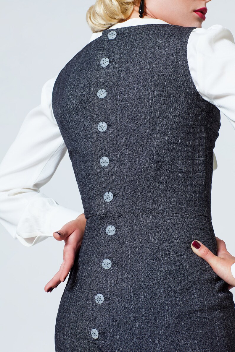 May include: A gray dress with a row of decorative buttons down the back.