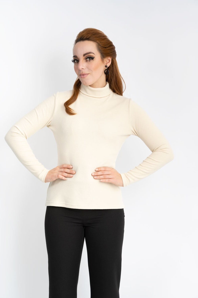 Kuschlig weicher cremefarbener Rollktagenpullover in Rippenoptik aus Viskose-Jersey. Dieser Pulli ist sehr dehnbar und super weich und passt wunderbar zu allen Unterteilen.