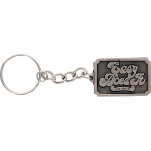 May include: A silver-colored keychain with a rectangular pendant. The pendant has the words "Easy Does It" in a stylized font, with "BUT DO IT" below. The keychain includes a chain and a round key ring.