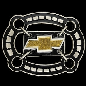 May include: A black and silver belt buckle with a gold Chevrolet logo. The buckle has a unique design with two circles on either side of the logo.