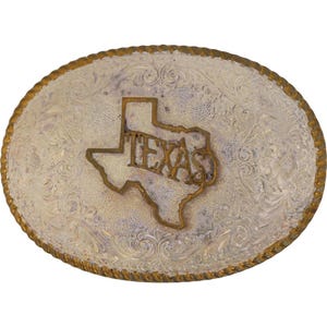 Peut inclure: Boucle de ceinture ovale argentée avec un bord en corde dorée. La boucle présente un contour en relief de l'État du Texas avec le mot "TEXAS" au centre. Le fond présente un motif floral.