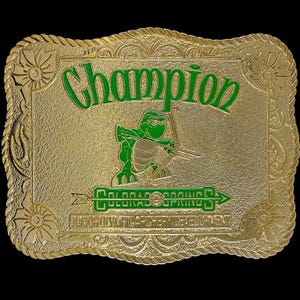 May include: Gold-colored belt buckle with a green turtle design and the words "Champion" and "Colorado Springs" in green lettering.