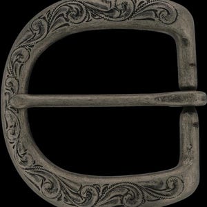 May include: A silver-toned metal belt buckle with an engraved floral design. The buckle is D-shaped with a horizontal bar and features detailed scrollwork along the edges. The background is black.