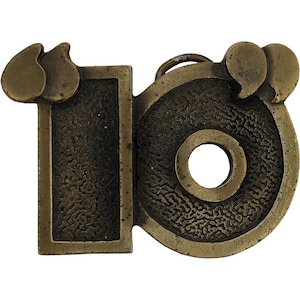 May include: A vintage brass belt buckle with the number "16" in a stylized design. The buckle features a rectangular "1" and a circular "6" with a textured surface and a small loop for the belt. The buckle has a tarnished, antique finish.
