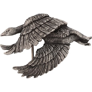 May include: A silver-toned metal sculpture of two geese in flight. The geese are depicted with detailed wings and feathers.