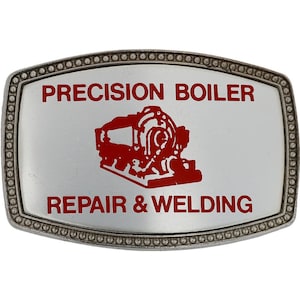 Puede incluir: Hebilla de cinturón rectangular plateada con borde decorativo. La hebilla presenta las palabras "PRECISION BOILER" y "REPAIR & WELDING" en rojo, junto con una ilustración roja de una caldera.