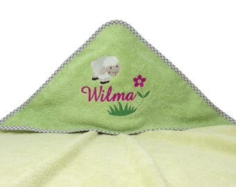 Könnte beinhalten: Grünes Kapuzenhandtuch mit einer Stickerei aus einem weißen Schaf und einer Blume. Das Handtuch hat einen karierten Rand und den Namen "Wilma" aufgestickt.