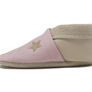 Pode incluir: Sapatos de beb&eacute; de couro rosa com acabamento em camur&ccedil;a bege e estrelas douradas com glitter.