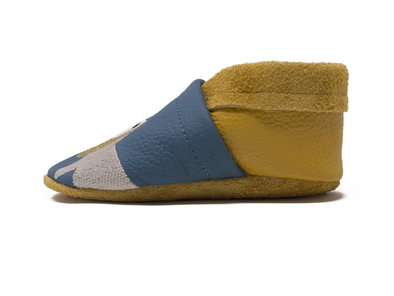 May include: Blue and yellow leather baby booties with a gray and white pattern on the toe.