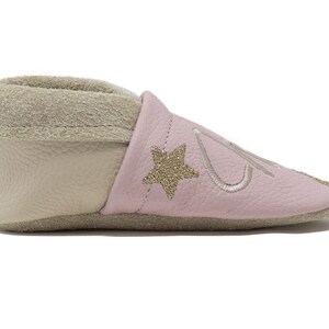 Pode incluir: Sapatos de beb&eacute; de couro rosa com uma estrela dourada e um design bordado. Os sapatos t&ecirc;m um forro bege macio.