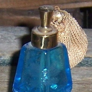 Botella de perfume de cristal tallado azul con atomizador, estilo vintage decorativo.