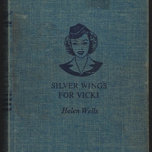 May include: A blue book cover with a black and white illustration of a woman wearing a hat and a uniform. The title of the book is "Silver Wings for Vicki" and the author is "Helen Wells".