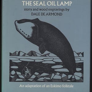 Puede incluir: Portada de libro con el título "THE SEAL OIL LAMP" e información del autor. La portada presenta una ilustración en blanco y negro de una ballena y una figura esquimal en un barco, sobre un fondo azul. El libro es una adaptación de un cuento esquimal.