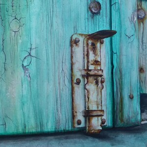 May include: A rusty metal latch on a weathered turquoise wooden door. The door has cracks in the paint and is showing signs of age.