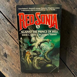 May include: A paperback book titled Red Sonja 5 Against the Prince of Hell by David C. Smith and Richard L. Tierney. The cover features a red-haired warrior holding a sword, a large eagle, and a green snake against a dark, moody background.