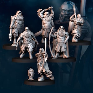 Peut inclure: Sept figurines miniatures de nains, chacune avec une pose et une arme uniques, y compris un arc et des flèches, une hache et une épée. Les figurines sont peintes dans un schéma de couleurs gris et sont debout sur des bases circulaires.