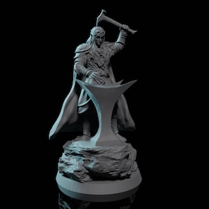Puede incluir: Una figurita gris de un elfo sosteniendo un martillo y de pie sobre una base de roca. El elfo lleva una capa y tiene el pelo largo.