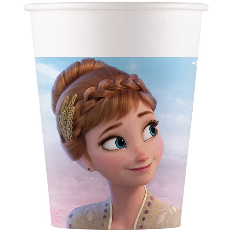 May include: A white paper cup with a colorful image of Anna from Frozen II. Anna is wearing a light brown dress with a gold hair accessory and has a light blue background behind her.