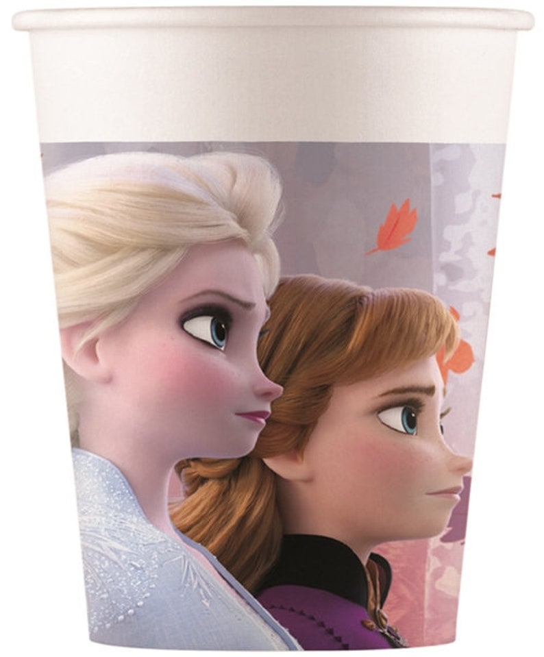 May include: A white paper cup with a design featuring Elsa and Anna from the movie Frozen. The cup has a purple, pink, and white background with a design of falling leaves.
