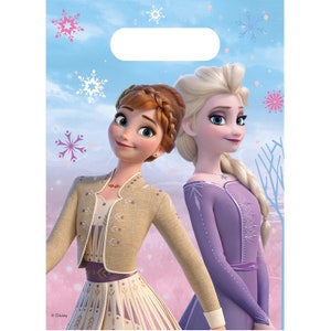 May include: Two Disney Frozen characters, Anna and Elsa, are featured on a blue and pink background with snowflakes. Anna is wearing a tan dress with a brown jacket and Elsa is wearing a purple dress with a snowflake necklace. The image is for a party favor bag.
