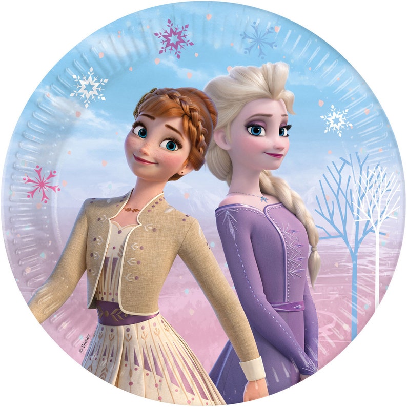 May include: Two Disney Frozen characters, Anna and Elsa, are featured on a round paper plate. Anna is wearing a brown jacket and a long, patterned dress. Elsa is wearing a purple dress with a snowflake design. The background is a light blue with snowflakes and trees.
