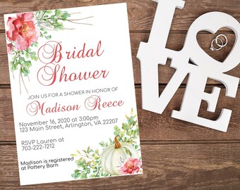 May include: A white card with a pink and green floral design. The text on the card reads "Bridal Shower" and includes the name "Madison Reece". The card also includes the date and time of the event, the address, and the RSVP information.