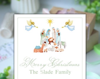 May include: A white Christmas card with a green border. The card features a watercolour illustration of the nativity scene with angels, a star, and the text "Merry Christmas The Slade Family".