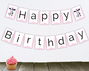 Peut inclure: Une bannière rose et blanche avec les mots "Happy Birthday" et deux illustrations de vaches noires et blanches. Un cupcake rose avec des pépites blanches est au premier plan.